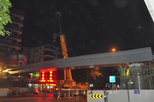 长38米、沉达87吨的钢箱梁，被200吨吊车稳稳地吊装在两个桥梁墩柱之上